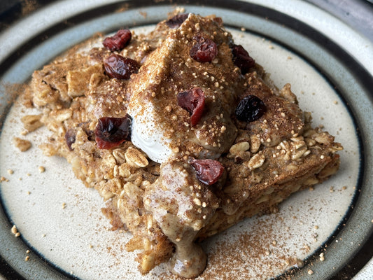 square of baked oatmeal with yogurt, craisins, and cinnamon on top